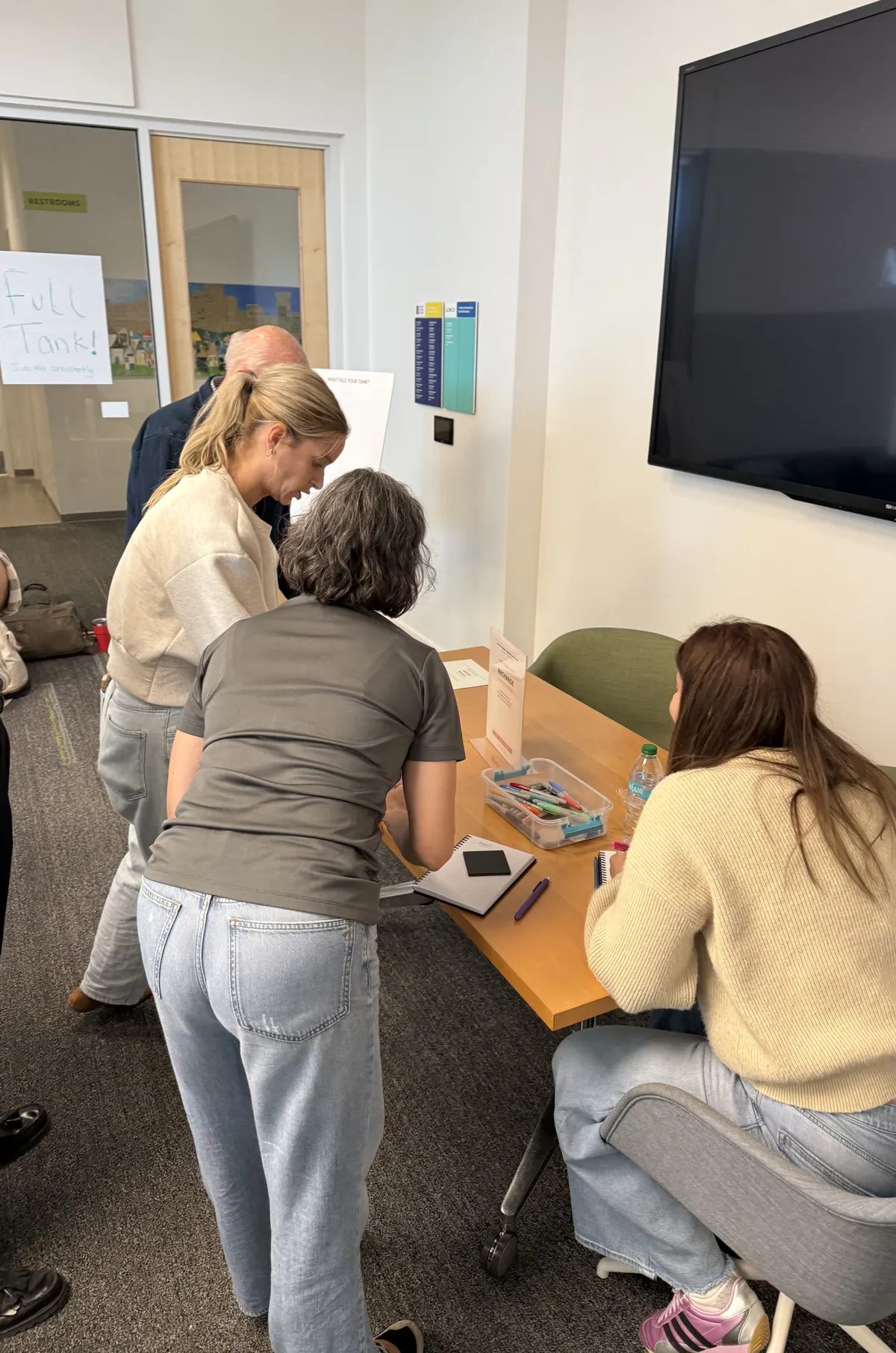 Employees gathered around a table during a Peace of Serenity wellness workshop