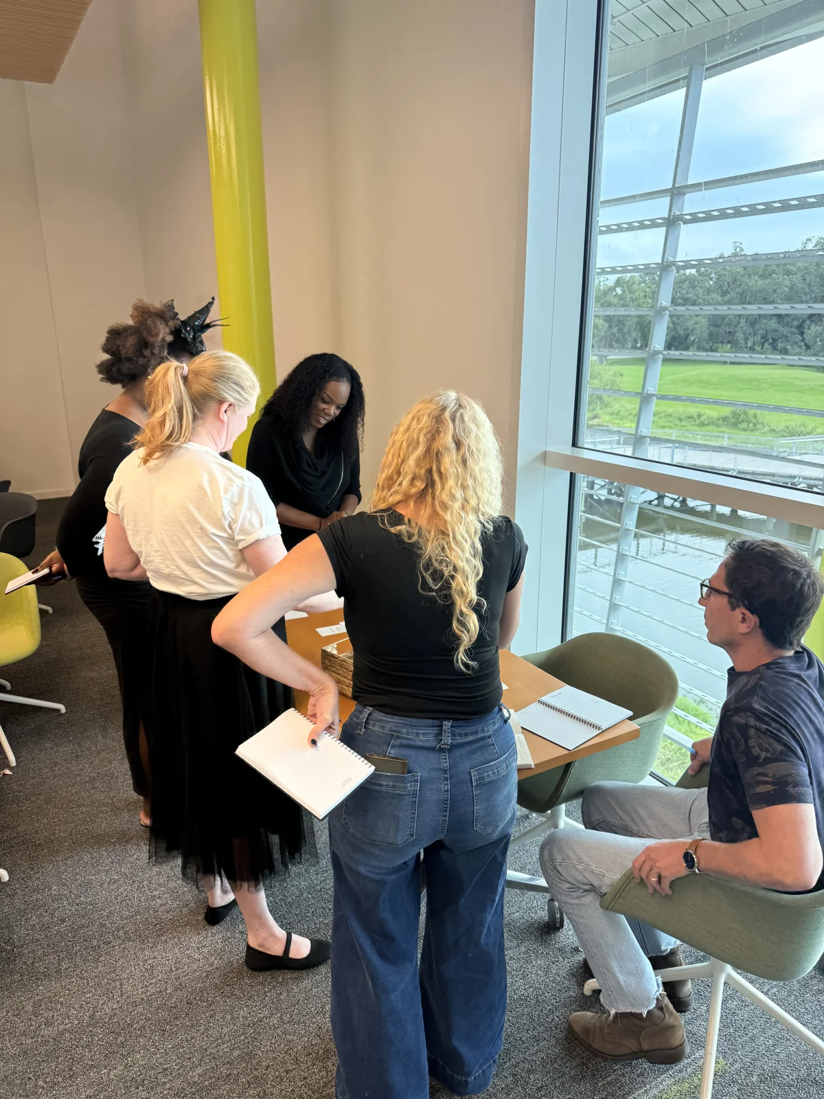 Employees standing together by a table during a Peace of Serenity workshop